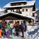 Skifahrende stehen vor dem Sportclub