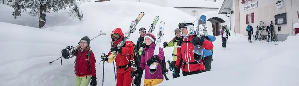 Skifahrer gehen zum Skibus