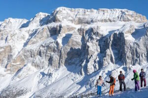 Skifahrer stehen auf der Piste bei der Skisafari Dolomiten