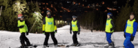 Kindergruppe auf Piste beim Nachtskifahren