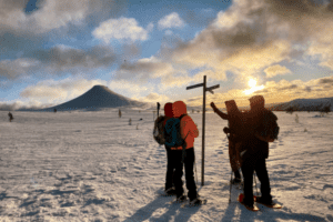 Vier Personen an Wegweiser im Schnee