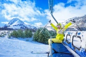 Skifahrer jubelt auf Lift in die Kamera