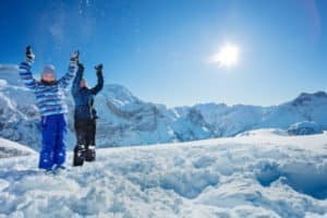 Zwei Kinder werfen Schnee in die Luft