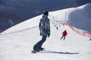 Snowboarder mit gemusterter Jacke auf der Piste