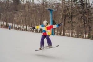 Snowboarder mit bunter Jacke im Sprung