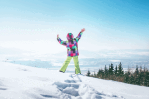 Kind steht im Schnee beim Bergsport