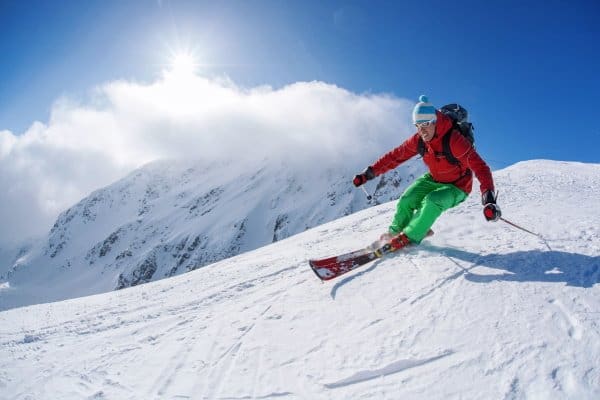 Skifahrer in Aktion mit roter Jacke