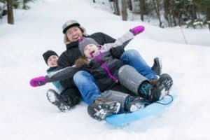 Familie beim Rodeln im Skigebiet Stubaital