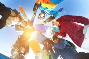 Gruppe von Wintersportlern stehen im Kreis bei Mannschaftsfahrt Winter