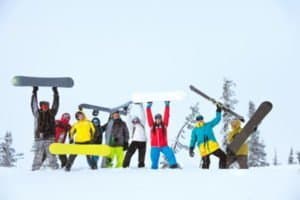 Snowboard und Skifahrer Gruppenfoto mit Sportgeräten in der Luft