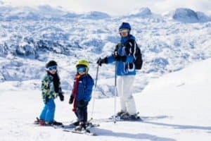 Mutter mit zwei Kindern auf der Piste im Skiurlaub im Allgäu