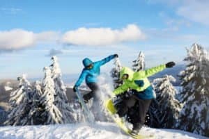 Zwei Snowboarder wirbeln Schnee auf