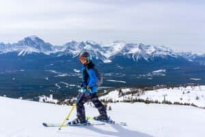 Junge in blauer Jacke steht vor Pistenbeginn