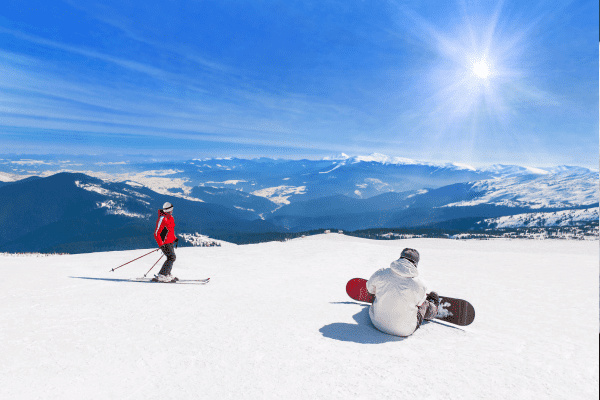 Ski- und Snowboardfahrer bei besten Bergwetter