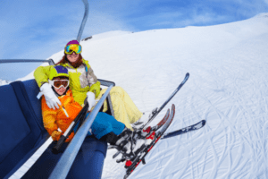 Mutter mit Kind im Sessellift im Skiurlaub Erzgebirge