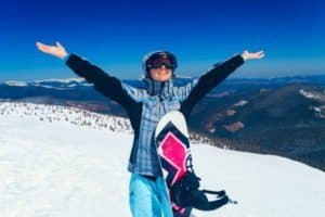 Glückliche Snowboarderin im Skigebiet in Zermatt