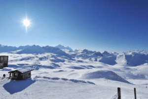 Blick auf eine Skihütte vor einem Bergpanorama
