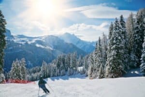 Junger Skifahrer fährt Richtung Sonne