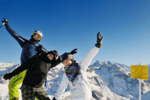 Drei Jugendliche freuen sich auf der Piste bei Ski Gruppenfahrten
