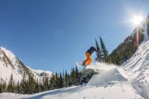 Snowboarder springt über Rampe