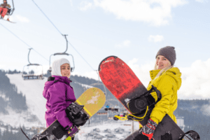 Zwei Mädchen mit Snowboards