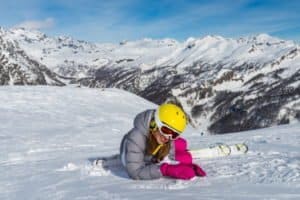 Mädchen liegt freudig im Schnee