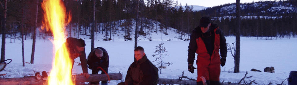 Lagerfeuer im Schnee mit Männern