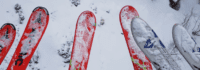 Skier in der Luft über Piste