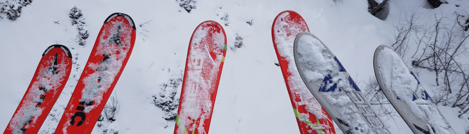 Skier in der Luft über Piste