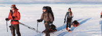 3 Personen mit Schneeschuhen und Schlitten