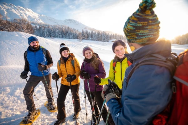 Gruppe höert einem Reiseleiter im Schnee zu
