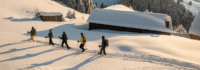 Gruppe läuft hinter einander durch den Schnee