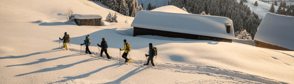 Gruppe läuft hinter einander durch den Schnee