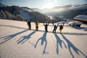 Gruppe mit Armen in der Luft im Schnee