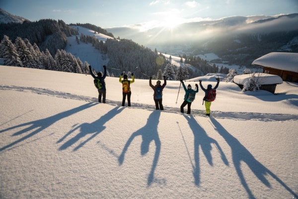 Gruppe mit Armen in der Luft im Schnee