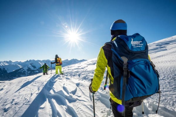 Wanderer auf Bergipfel im Schnee und mit Sonne