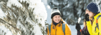Zwei Frauen lachen sich im Schnee an