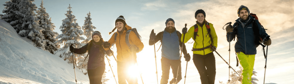 fünf Menschen laufen im Schnee auf die Kamera zu