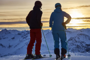 Zwei Skifahrer von hinten bei Sonnenuntergang im Single-Skiurlaub Arosa Lenzerheide