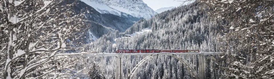 Eisenbahn fährt im Winterwunderland über eine Brücke