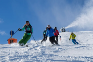 Eine Gruppe Skifahrer fährt hintereinander auf der Piste