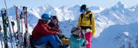 Vier Skifahrer machen Pause auf dem Gipfel