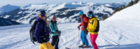 Vier Skifahrer warten lachend auf der Piste